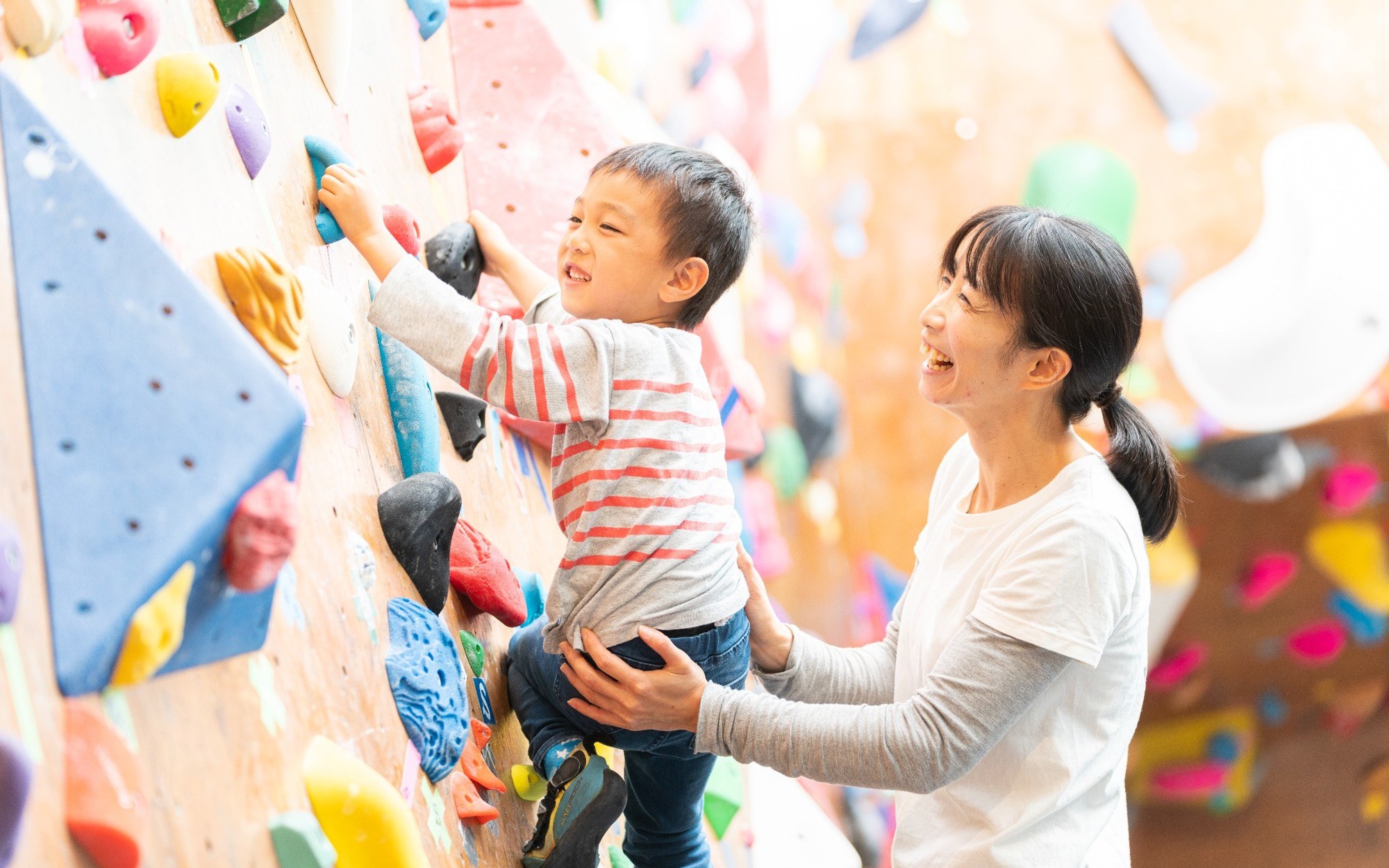子どもの登りをそばで支える保護者