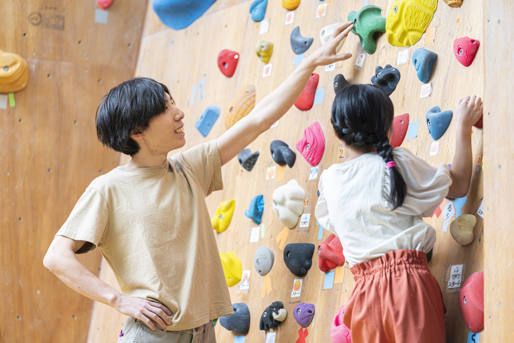 子どものボルダリングを近くで見守る保護者